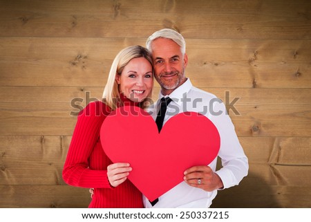 Handsome man getting a heart card form wife against bleached wooden planks background