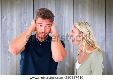 Man not listening to his shouting girlfriend against wooden planks