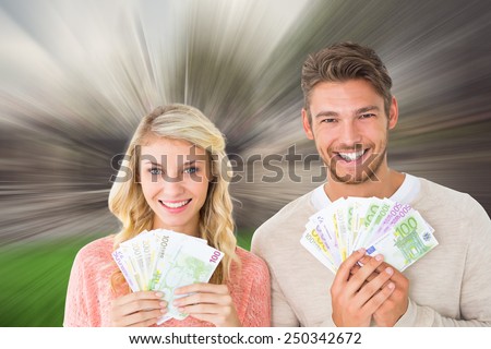 Attractive couple flashing their cash against sunny day by the river