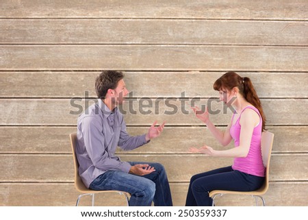 Sitting couple having an argument against wooden surface with planks