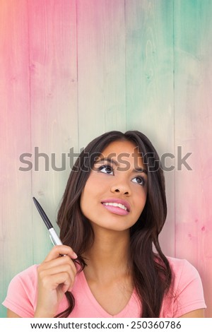 Pretty brunette thinking against pink and green planks