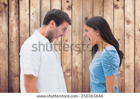 Angry couple shouting at each other against wooden planks