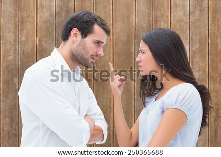 Angry couple facing off during argument against wooden planks