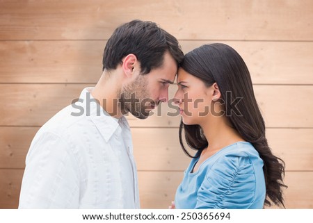 Angry couple staring at each other against overhead of wooden planks