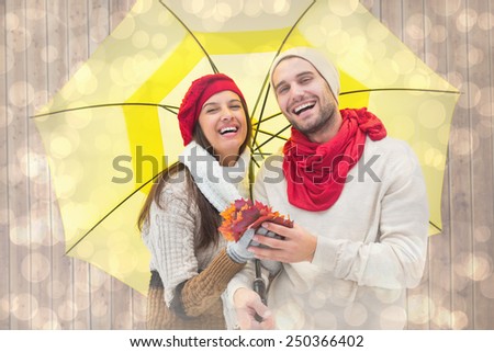 Autumn couple holding umbrella against light glowing dots design pattern