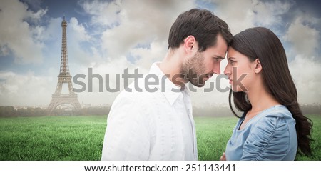 Angry couple staring at each other against eiffel tower