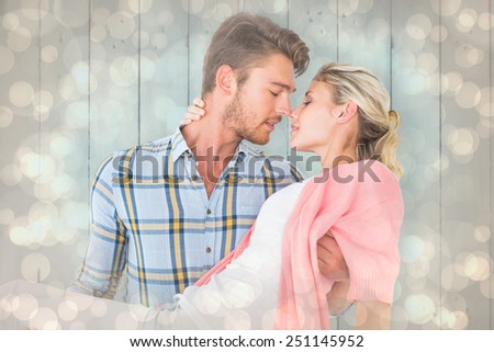 Handsome man picking up and hugging his girlfriend against light glowing dots design pattern