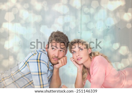 Attractive young couple lying and thinking against light glowing dots design pattern