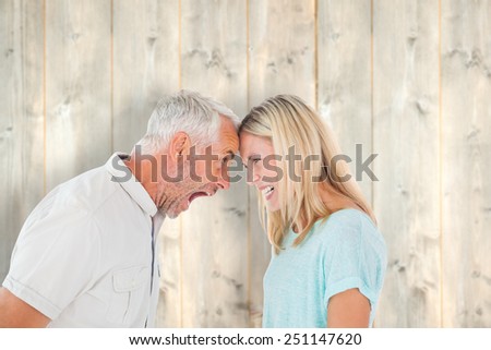 Unhappy couple having an argument against pale wooden planks