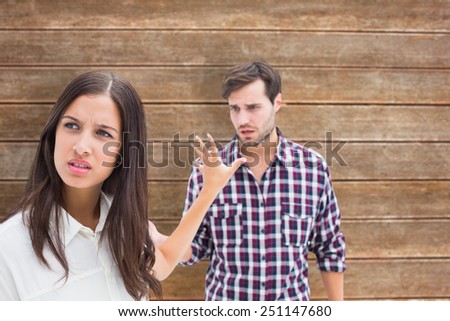 Angry brunette not listening to her boyfriend against wooden planks background