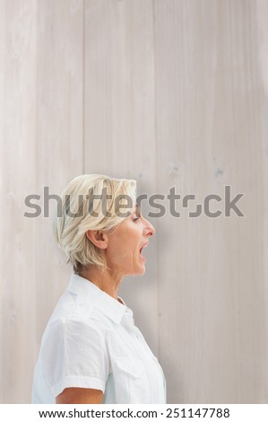 Happy mature woman talking loudly against bleached wooden planks background