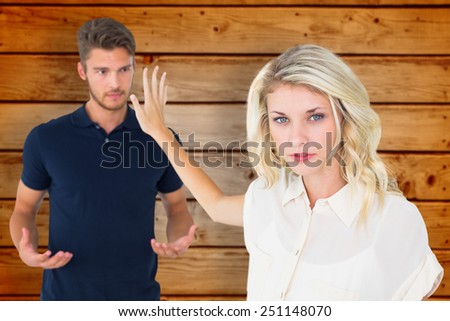 Young blonde not listening to boyfriend against wooden planks background