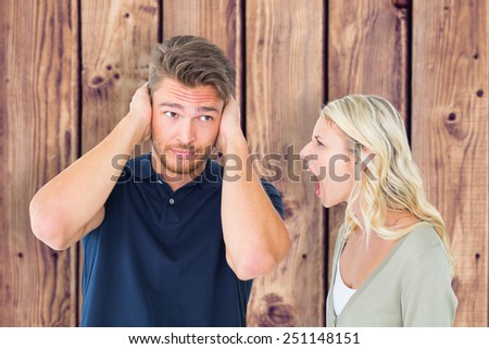 Man not listening to his shouting girlfriend against wooden planks background