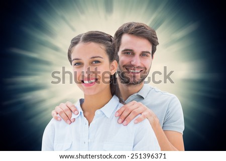 Cute couple smiling at camera against valentines heart design