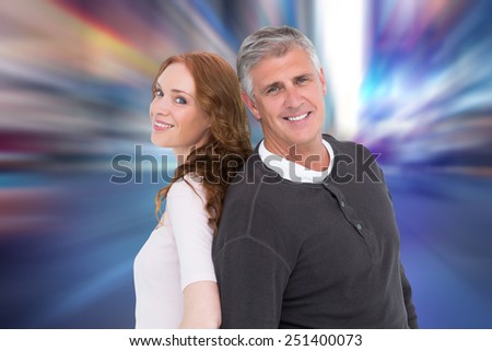 Casual couple smiling at camera against blurry new york street