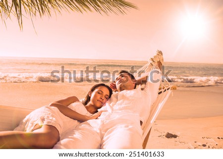 Calm couple napping in a hammock at the beach