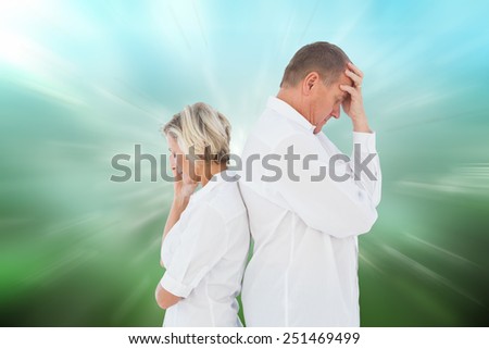 Upset couple not talking to each other after fight against digitally generated dandelion seeds on green background