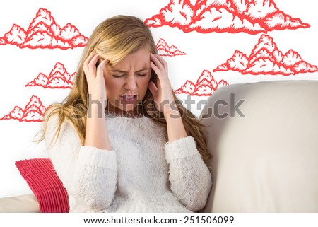 Woman with headache sitting on sofa against clouds