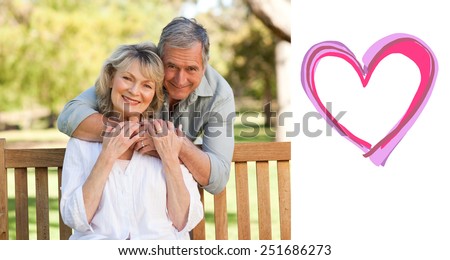 Elderly man hugging his wife who is on the bench against heart