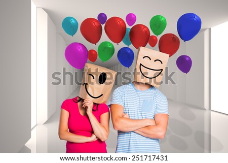 Young couple with bags over heads against digitally generated room with bright light