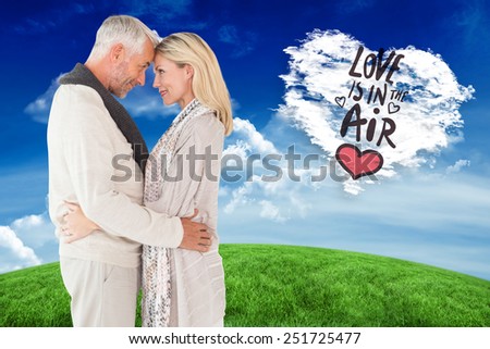 Happy couple standing and hugging against cloud heart