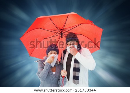 Mature couple blowing their noses under umbrella against blue abstract light spot design