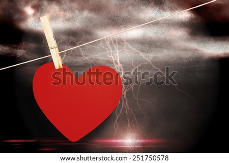 Heart hanging on line against stormy dark sky with lightning bolts