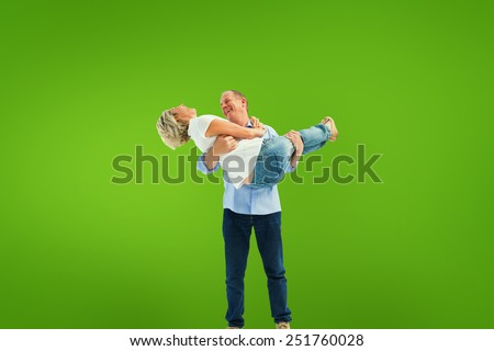 Mature man carrying his laughing partner against green vignette