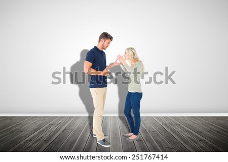 Young couple having an argument against grey room