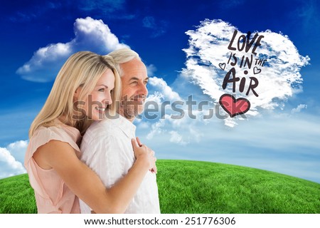 Affectionate couple standing and hugging against cloud heart