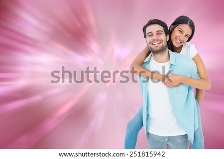 Happy casual man giving pretty girlfriend piggy back against digitally generated love heart background