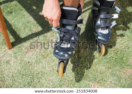 Man putting on his roller blades on a sunny day