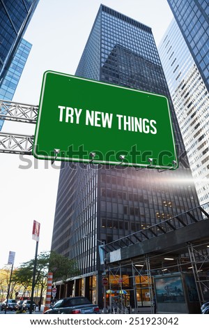 The word try new things and green billboard sign against skyscraper in city