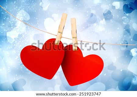 Hearts hanging on line against valentines heart design
