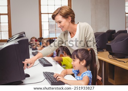 Cute pupils in computer class with teacher at the elementary school