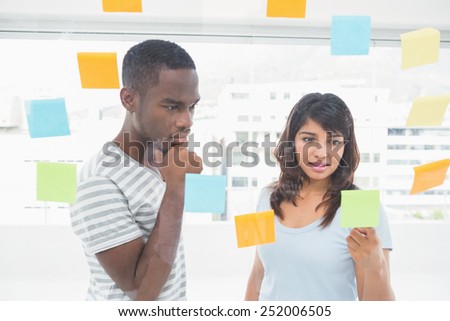 Concentrated coworkers reading sticky words in the office