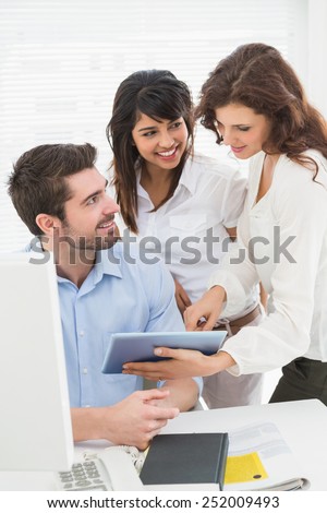 Happy partners using digital tablet together in the office