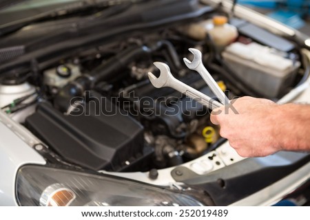 Mechanic holding two types of wrench in the repair garage