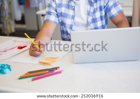 College student using laptop while drawing picture at the college