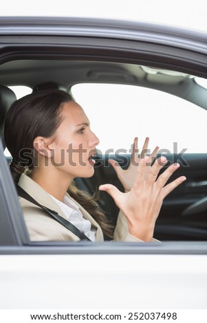 Young woman experiencing road rage in her car