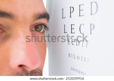 Focused man on eye test letters on white background