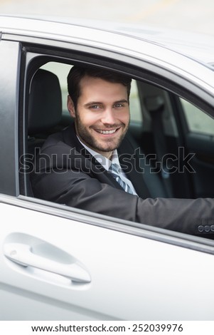 Happy businessman in the drivers seat in his car