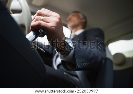 Man using a gear stick in a car dealership at new car showroom
