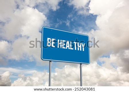 The word be healthy and blue billboard sign against blue sky with white clouds