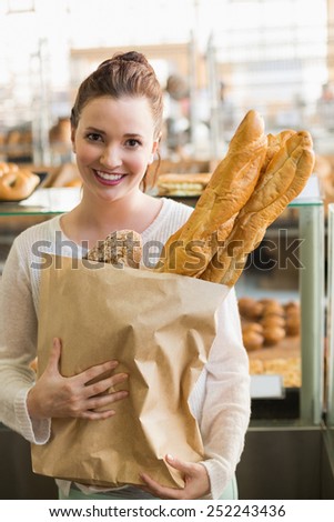 Pretty brunette with bag of bread at the bakery