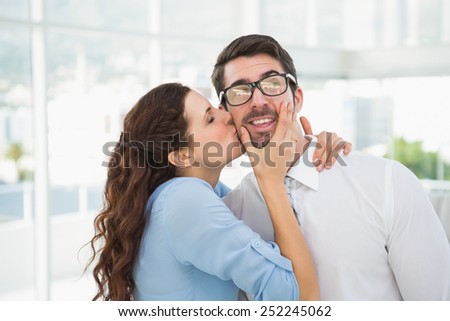 Portrait of a woman kissing her colleague in the office