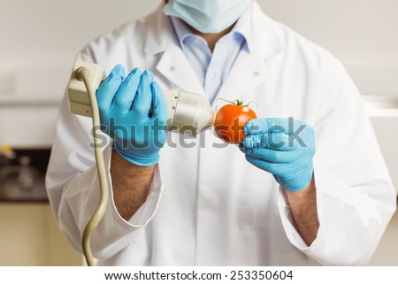 Food scientist using device on tomato at the university