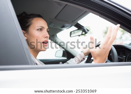 Pretty businesswoman experiencing road rage in her car