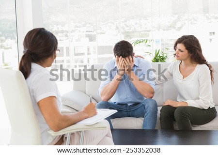 Depressed couple talking with their therapist in the office