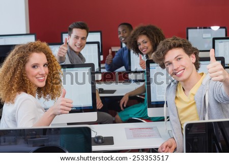 Students smiling at camera in computer class at the college